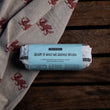 Load image into Gallery viewer, Roll of ready-to-bake Welshcake dough on a wooden surface with a welsh dragon patterned cloth.