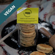 Load image into Gallery viewer, Packaged Vegan Cheese & Leek Welsh Cakes on a busy kitchen work top with rolling pin, wooden spoon, cooling rack and griddle