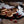 Load image into Gallery viewer, Stack of cherry bakewell welsh cakes with cherries on a rustic surface with a rolling pin and flour container.
