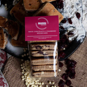 Pack of MamGu Welshcakes White Chocolate & Cranberry Welsh cakes with ingredients on a rustic background