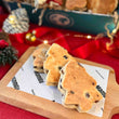 Load image into Gallery viewer, Three Christmas tree Welsh cakes on a wooden board with Christmas decorations in the background
