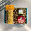 Load image into Gallery viewer, Curried Masala Savoury Gift Box - a teal cardboard box filled with packaging with a pack of curried masala welsh cakes with a orange label, a red wax chilli &amp; Tomato cheese, and green label jar of chutney
