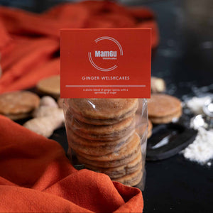 packaged ginger welsh cakes with a mamgu welshcakes label, orange table cloth on a black work top