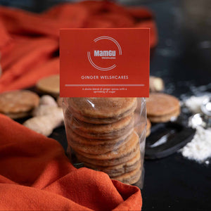 packaged ginger welsh cakes with a mamgu welshcakes label, orange table cloth on a black work top