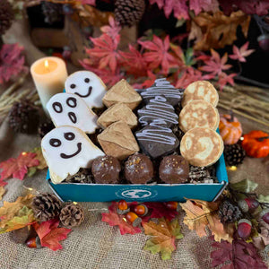 Halloween Welsh Cakes neatly displayed in a blue gift box next to autumn themed table decorations 
