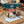 Load image into Gallery viewer, Chocolate-dipped welsh cake treats on a wooden board with &#39;MamGu Welshcakes&#39; branding, blurred background of more treats and autumn decorations
