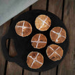 Load image into Gallery viewer, 6 Hot Cross Bun Welshcakes on top of each other presented on a black bakestone / griddle, with a hessian and wood background. 
