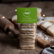 Load image into Gallery viewer, Pack of Lime and Coconut Welsh Cakes on a rustic kitchen work top with a wooden rolling pin, wooden chopping board, and loose desiccated coconut 
