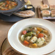 Load image into Gallery viewer, Vegetable cawl in a white bowl. 
