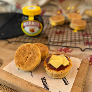 3 welsh cakes with cheese and marmite on, with a black cooling rack and jar of marmite in the background. 