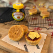 Load image into Gallery viewer, 3 welsh cakes with cheese and marmite on, with a black cooling rack and jar of marmite in the background. 
