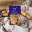 Load image into Gallery viewer, Packaged Milk Chocolate Chip Welsh Cakes with purple mamgu welshcakes branding on a rustic kitchen work top
