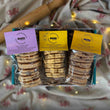 Load image into Gallery viewer, 3 packs of welsh cakes in a teal gift box, with a blurred background including a beige tablecloth with red dragons and a wooden rolling pin.
