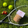Load image into Gallery viewer, 6 pack of strawberries and cream welsh cakes on a tennis racket, with balls, and strawberries on the grass.
