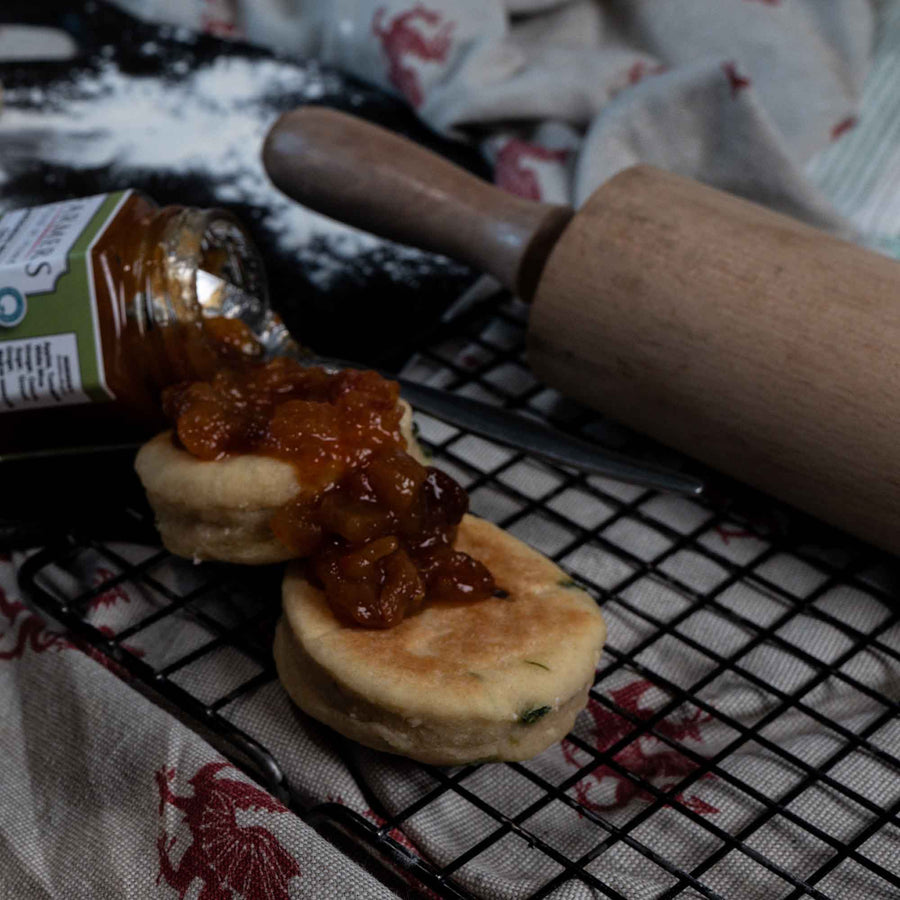 Vegan Cheese and Leek Welsh Cakes on a cooling rack with a chutney on top