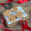 Load image into Gallery viewer, Chocolate Chip Welsh Cakes on a wooden chopping board with a red ribbon around it
