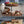 Three-tiered wooden dessert tower with welsh afternoon ingredients, bara brith, jam, welsh cakes, welsh cheese with a blurred background.