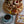 Three-tiered wooden dessert tower with welsh afternoon ingredients and a cup of coffee on a marble surface.
