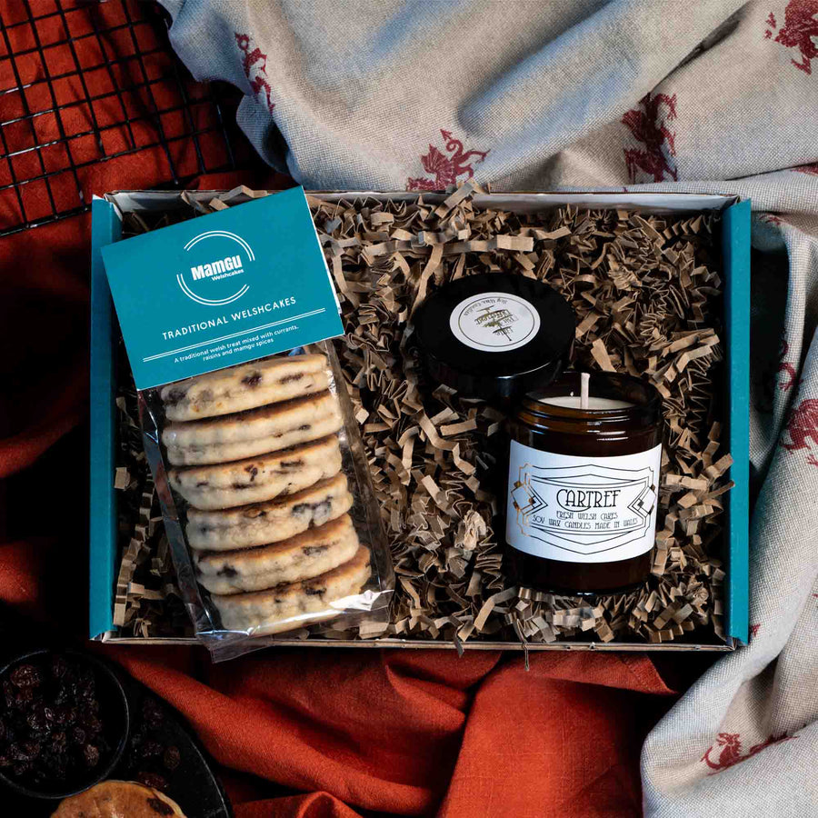 Gift Box with packaged Traditional Welsh Cakes and a Welsh Cake scented candle displayed on an orange and welsh dragon table cloth