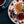 Plate with traditional welsh cakes topped with jam and clotted cream, next to a cup of tea on a dark surface.