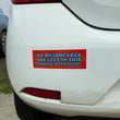 Load image into Gallery viewer, A rectangular red bumper sticker with blue and light blue text reading 'NO WELSHCAKES ARE LEFT IN THIS VEHICLE OVERNIGHT' applied to the rear bumper of a white car.
