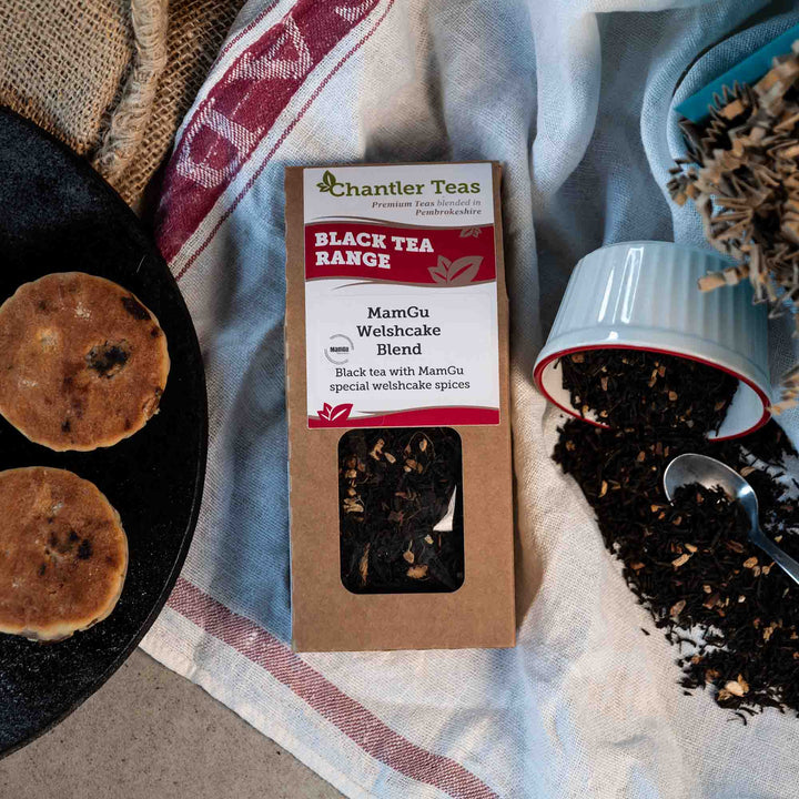 chantler teas mamgu welsh cake blend loose leaf tea in a cardbard box on a tea cloth next to loose tea and welsh cakes
